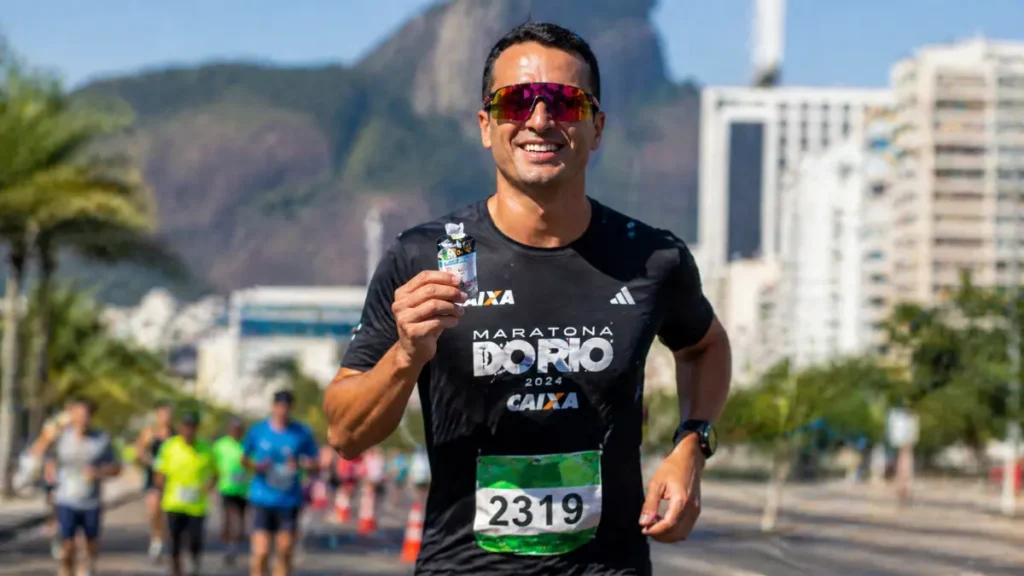 corredor tomando gel carboidrato antes de prova corrida de rua
