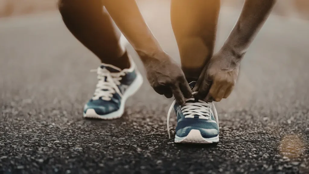 corredor amarrando o tenis